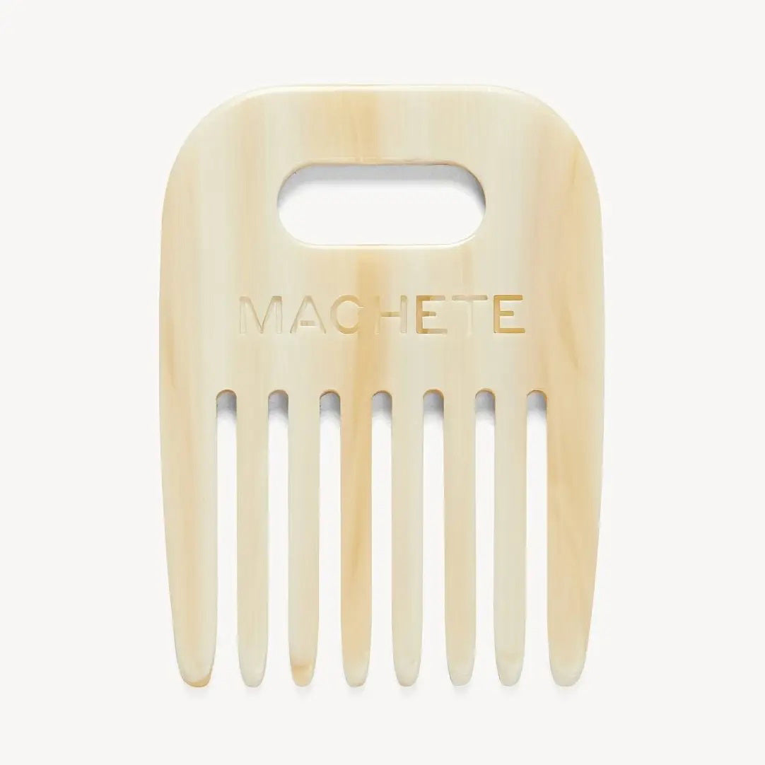 The MACHETE - NO. 4 COMB IN ALABASTER is a cream, wide-tooth rectangular hair comb made from Italian acetate, featuring a rounded top, oval handle cutout, and "MACHETE" engraving—perfect for curly hair.
