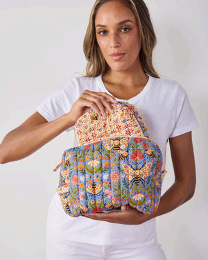 The PRINTFRESH Bee Tapestry Oversized Pouch Duo in Delphinium Blue features two quilted makeup pouches: the larger pouch showcases a blue bee and floral print, while the smaller pouch displays a cream background with red, yellow, and blue geometric shapes. Both PRINTFRESH bags are displayed on a tiled surface.