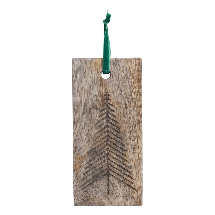The CREATIVE COOP MANGO WOOD CUTTING BOARD WITH ETCHED TREE features a simple laser-etched tree design and a green hanging ribbon, making it both functional and decorative.
