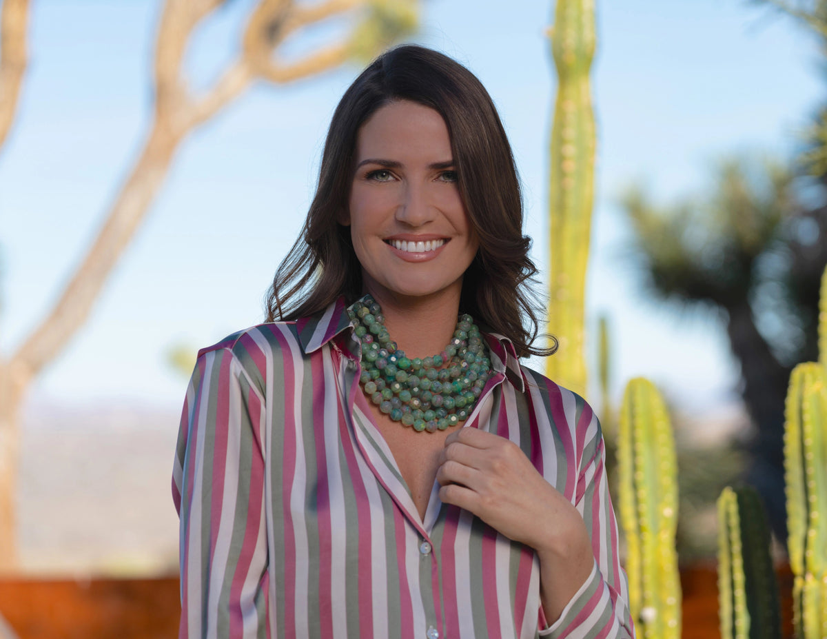 The FAIRCHILD BALDWIN - THE BELLA NECKLACE showcases layered strands of iridescent green Italian resin beads with a faceted design for a shimmering effect, finished with a smooth light green clasp that complements its vibrant hues.