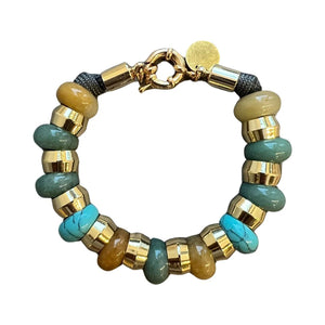 The HOLST & LEE - SEMI PRECIOUS BRACELET by HOLST & LEE is a chic accessory featuring alternating round, metallic gold and translucent brown beads. It has a unique clasp and a small, circular charm hanging from it. The evenly spaced and polished beads give it a stylish and elegant look.