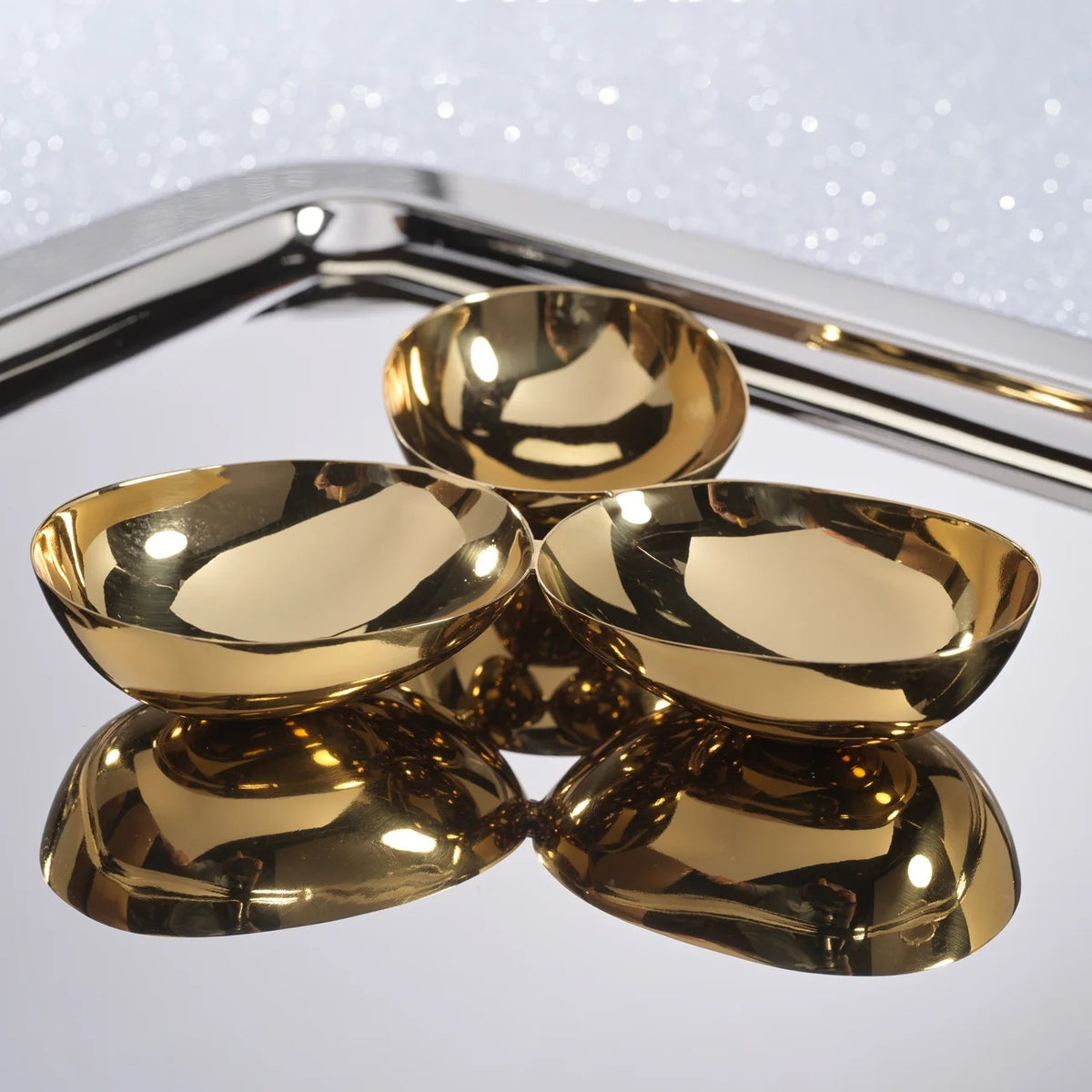 ZODAX TRIPLE NUT BOWL IN POLISHED GOLD featuring three connected 7-inch gold-toned bowls arranged in a cluster.