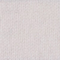 A person with long dark hair tied back stands confidently with one hand on their hip, wearing a KINROSS CASHMERE - TIE FRONT VEE PULLOVER by KINROSS. The 100% cashmere, 2ply, 9gg orange V-neck sweater features a stylish front tie detail and is paired elegantly with white wide-leg pants. The background is plain white.