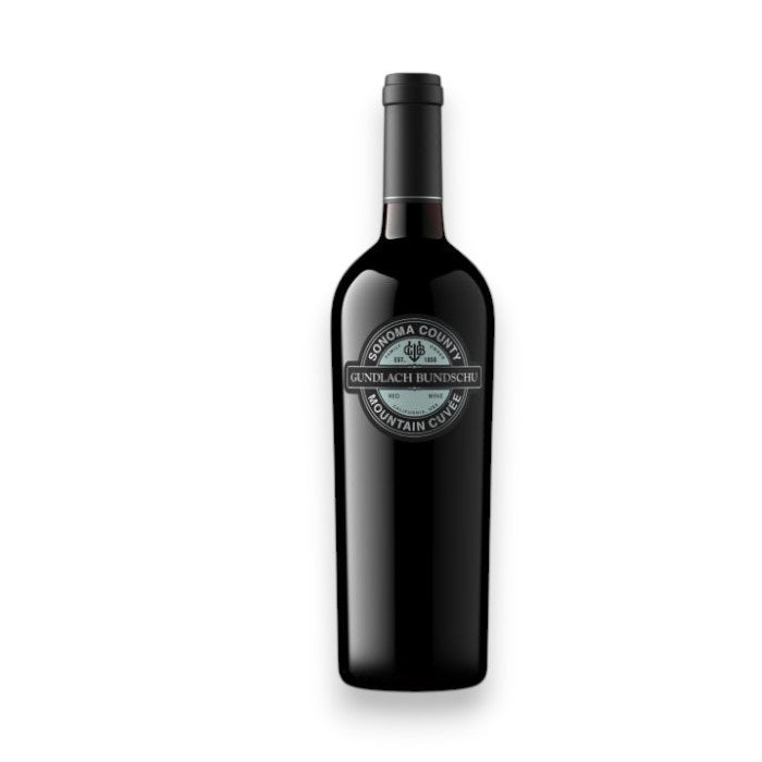 A dark glass wine bottle with a black "GUNDLACH-BUNDSCHU 'MOUNTAIN CUVEE' CAB-MERLOT 2023" label by WINE: TRYON is displayed against a white background, highlighting this Sonoma Valley red blend.