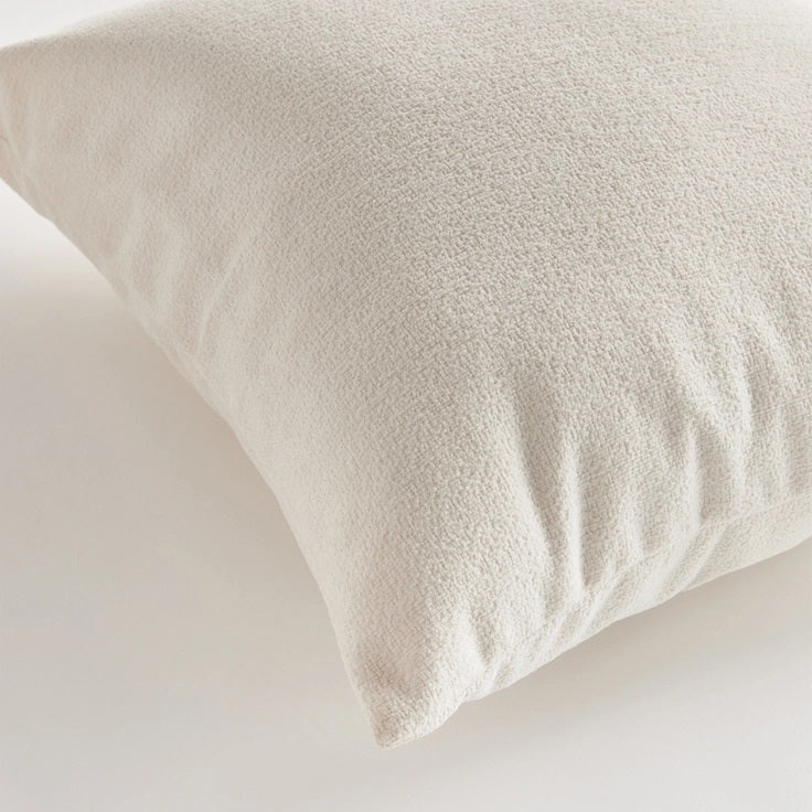 Against a plain white background, the NAPA HOME AND GARDEN - COOPER SQUARE INDOOR-OUTDOOR PILLOW 20&quot;, with its soft and fluffy Jacquard texture, appears smooth and slightly plump, ideal for resting or sleeping in any weather-resistant setting.