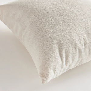 Against a plain white background, the NAPA HOME AND GARDEN - COOPER SQUARE INDOOR-OUTDOOR PILLOW 20", with its soft and fluffy Jacquard texture, appears smooth and slightly plump, ideal for resting or sleeping in any weather-resistant setting.