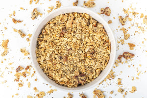 A white bag of STRUESLI - ORIGINAL ORGANIC GRANOLA is displayed against a simple backdrop. The packaging emphasizes that it contains ingredients such as tiger nuts, pecans, walnuts, coconut flakes, among others. Notable features include the absence of sweeteners and grains, along with being rich in plant-based protein for a nutritious boost.