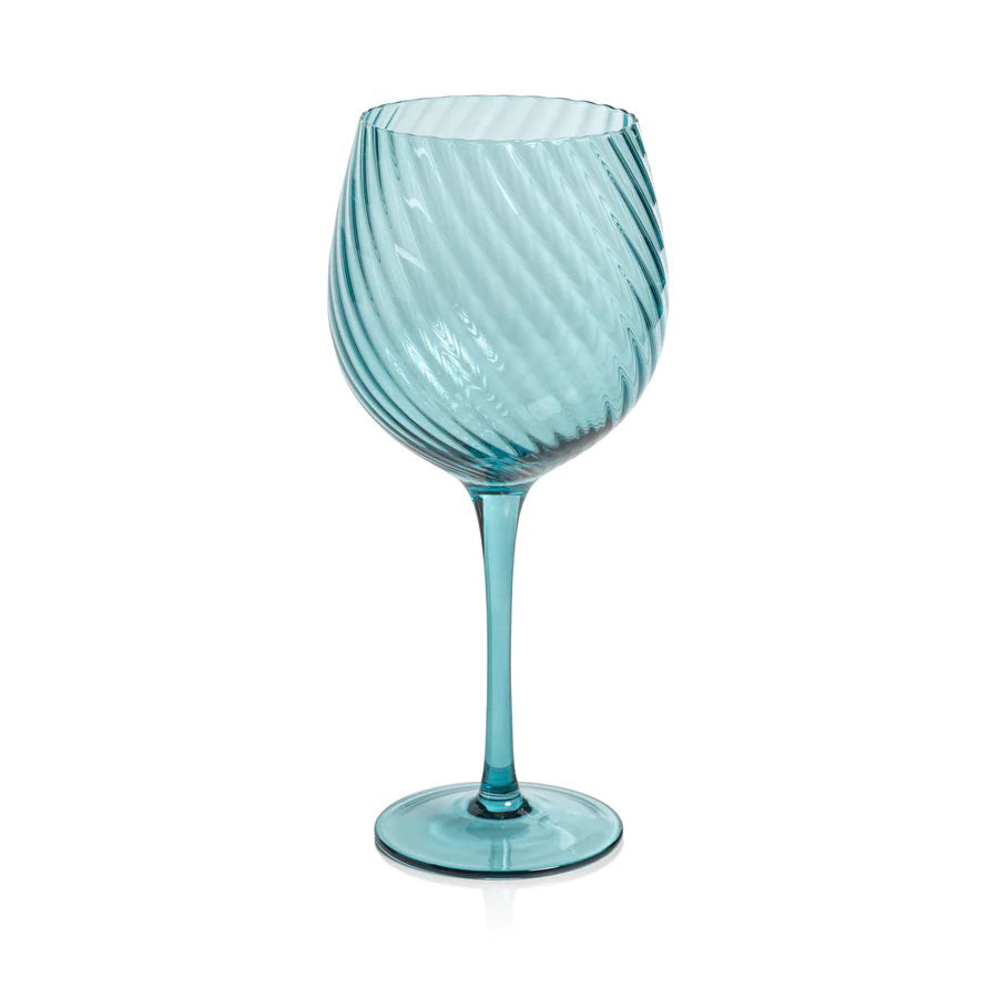The SAVOY OPTIC SWIRL RED WINE GLASS by ZODAX features a turquoise color with a swirling, ribbed pattern. It boasts a wide bowl, tall stem, and round base, along with a reflective glassy finish. This glass has a capacity of 600 ml.