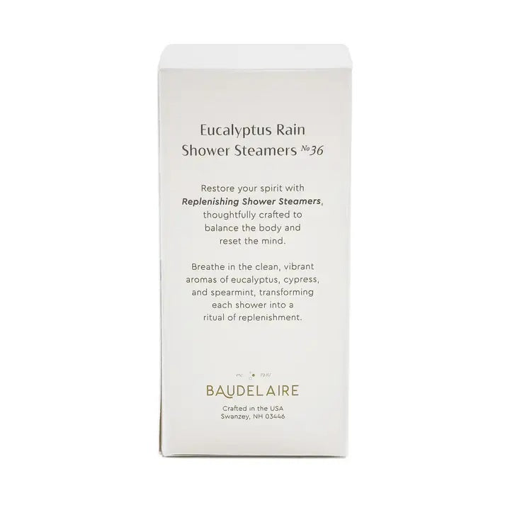 A white box labeled “BAUDELAIRE - REPLENISH EUCALYPTUS RAIN SHOWER STEAMER” by BAUDELAIRE, featuring a window that displays stacked round blue and white shower steamers inside, provides a refreshing aromatherapy experience with the invigorating scent of eucalyptus.