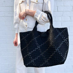 The PARKER & HYDE Oversized Woven Tote Bag is a hand-woven black tote with a matching pouch, both featuring a subtle crisscross pattern. The versatile tote has short handles and a sturdy texture, while the pouch includes a convenient zipper closure.