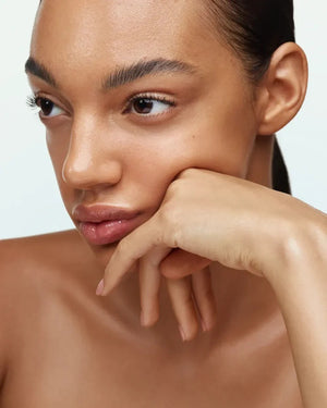 A bottle of U BEAUTY - THE SUPER TINTED HYDRATOR SHADE 8, featuring a white cap and frosted clear body with beige liquid, stands upright against a light gray background.