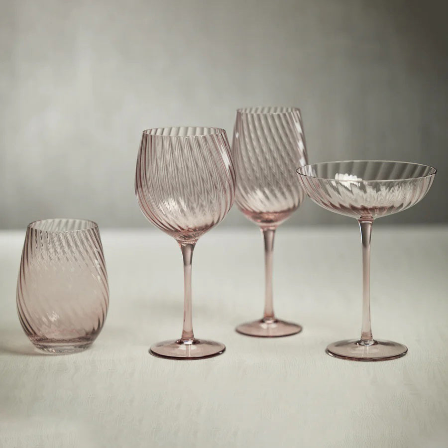 The SAVOY OPTIC SWIRL COCKTAIL GLASS by ZODAX features a clear, elegantly designed coupe with a subtle optic swirl pattern. Resting on a slender stem and circular base, this minimalist and sophisticated glass is perfect for serving cocktails or champagne.