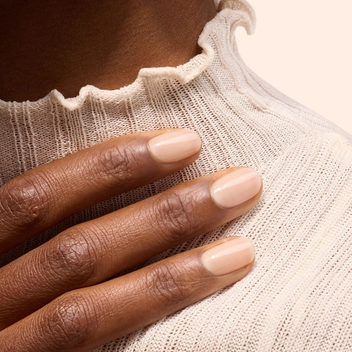 A bottle of MANUCURIST INC GREEN™ Nail Polish in beige, featuring a black cap and white label.