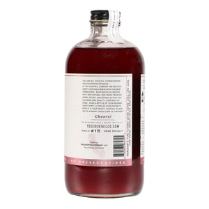 A transparent glass bottle holds a rich, dark red liquid labeled "YES COCKTAIL CO - Hibiscus Rose Cocktail Mixer." Handcrafted in California and available in a 16 fl oz (473ml) size, the white-and-red-toned label indicates its perfect suitability for creating cocktails or an exotic floral spritzer.