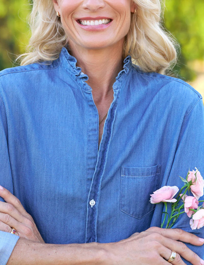 The FRANK &amp; EILEEN Ruffle Eileen Relaxed Button Up in Vintage Stonewashed Denim has rolled-up long sleeves, a casual frayed collar, front pocket, button-down front, and slightly curved hem. The label reads &quot;Frank &amp; Eileen EST 1947.