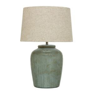 The CREATIVE COOP AQUA STONEWARE LAMP WITH LINEN SHADE features a nature-inspired design with a muted green textured ceramic base and a beige linen shade, set against a white background.