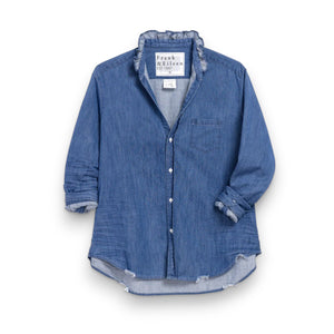 The FRANK & EILEEN Ruffle Eileen Relaxed Button Up in Vintage Stonewashed Denim has rolled-up long sleeves, a casual frayed collar, front pocket, button-down front, and slightly curved hem. The label reads "Frank & Eileen EST 1947.