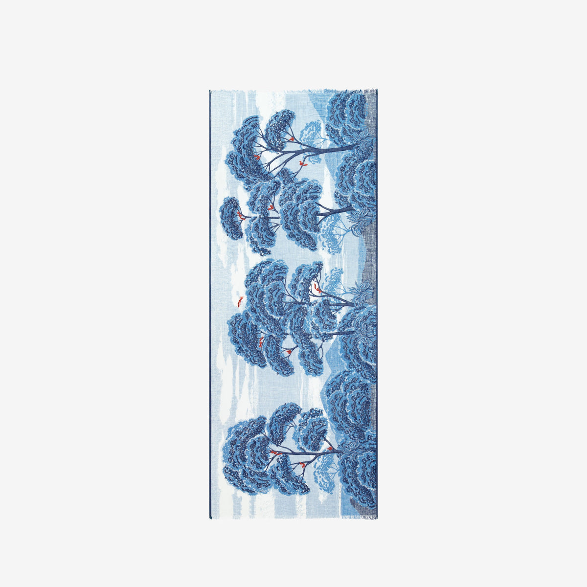A woman in a sleeveless beige dress faces forward, draped in the INOUI EDITIONS - AMBROISE SCARF IN DUCK BLUE by INOUI, featuring a dark blue botanical pattern on linen cotton. The background is plain white.