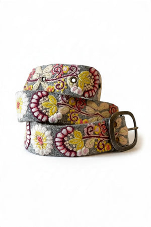 JENNY KRAUSS - HEATHER GRAY FLORAL EMBROIDERED WOOL BELT, coiled and handcrafted in Peru, featuring colorful floral embroidery and a dark metal buckle.