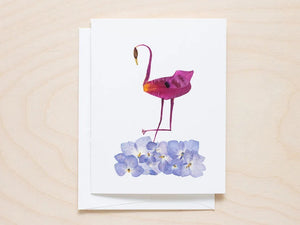The PETAL PEOPLE PRESS - FLAMINGO CARD features a flamingo artfully made from vibrant purple petals, surrounded by whimsical light blue and pink flowers on a white background.