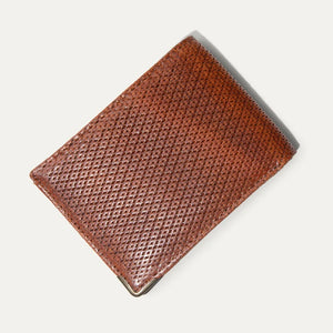 Two WILL LEATHER GOODS THE INDUSTRIALIST BILLFOLD wallets in ginger pindot full-grain leather are shown: one open with card slots and ID window, the other closed with an embossed dog logo on the bottom right corner.