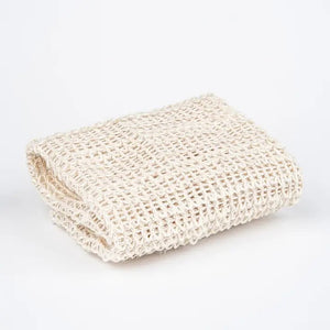 The BAUDELAIRE - SISAL WASH CLOTH by BAUDELAIRE is crafted from natural sisal fiber, harvested by hand, and features a woven texture with a brown paper label that reads “Baudelaire Sisal Wash Cloth, natural sisal fiber, harvested by hand.” This gentle exfoliator is ideal for daily cleansing or as a facial scrub, offering the benefits of natural sisal to your skincare routine.