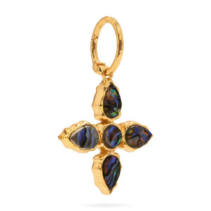 The CAPUCINE DE WULF AURORA pendant features a gold cross with four sustainably sourced blue-green abalone stones set in textured gold bezels. An elegant embellished loop enhances its wearability.