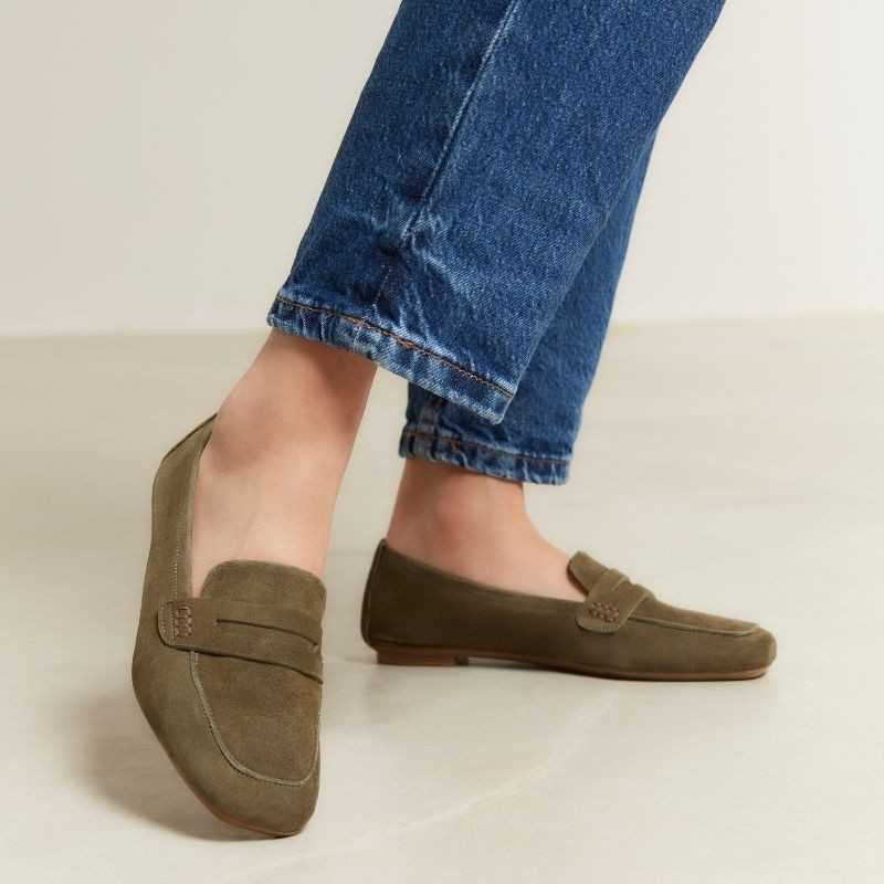 REQINS - HEMA suede loafers in olive feature a classic silhouette, flat sole, decorative upper strap, and comfortable leather insole, shown in side profile against a plain light background.