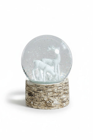 ZODAX SNOW GLOBE ON BIRCH WITH WHITE REINDEERS featuring two reindeer figures inside a glass globe set on a cylindrical, bark-textured birch base.