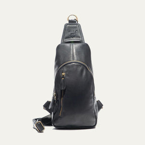 The WILL LEATHER GOODS - ZIP AROUND SLING BAG IN BLACK is a full-grain leather sling bag with gold zippers and buckle, small front pocket, adjustable strap, and top hanging loop, shown against a plain white background.