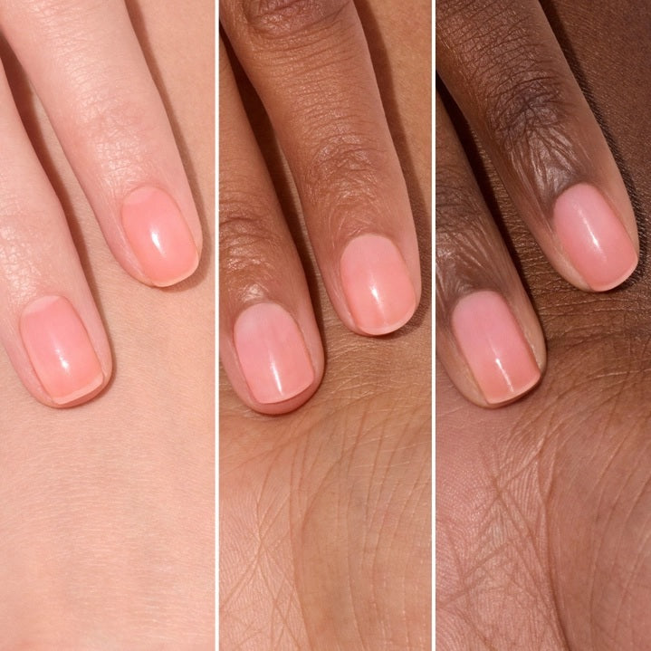 A pink serum drop labeled with its ingredients: raspberry extract (strengthens nails), AHAs (restore and harden), and sweet almond oil (nourishes). The text highlights that MANUCURIST - ACTIVE GLOW CARE POLISH by MANUCURIST INC is 85.5% plant-based—making it the ideal nail strengthener for achieving healthy, glass-like nails.