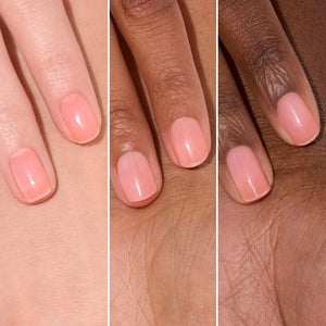 A pink serum drop labeled with its ingredients: raspberry extract (strengthens nails), AHAs (restore and harden), and sweet almond oil (nourishes). The text highlights that MANUCURIST - ACTIVE GLOW CARE POLISH by MANUCURIST INC is 85.5% plant-based—making it the ideal nail strengthener for achieving healthy, glass-like nails.
