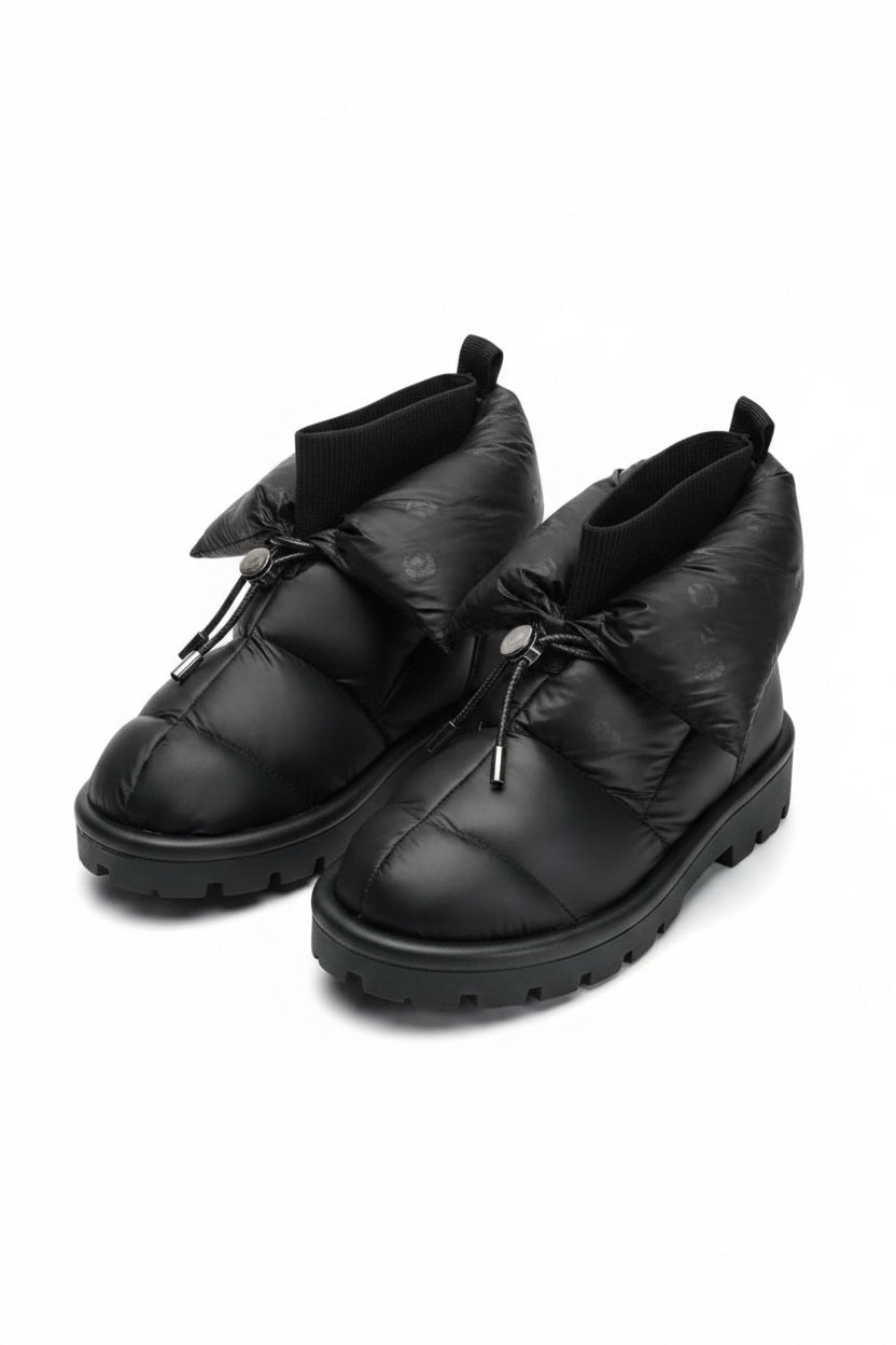 The FLUFIE METALLIC PILLOW BOOT is a pair of gray, insulated slippers with drawstring closures, a high folded collar, water repellent fabric in a subtle circular pattern, designed for warmth and shown on a white background.