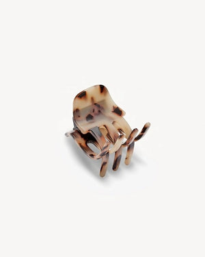 The MACHETE - MINI CLAW by MACHETE is an Italian acetate hair clip in a brown and beige tortoiseshell pattern, featuring a rounded top and multiple curved gripping prongs, shown against a plain white background.
