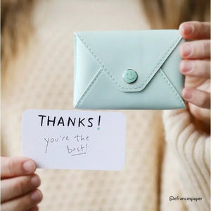 The E. FRANCES PAPER E. FRANNIE PACK, SEAGLASS is a mint green wallet with a snap closure, embossed with "E. FRANCES," ideal for holding Little Notes—perfect as a gift and shown against a white background.