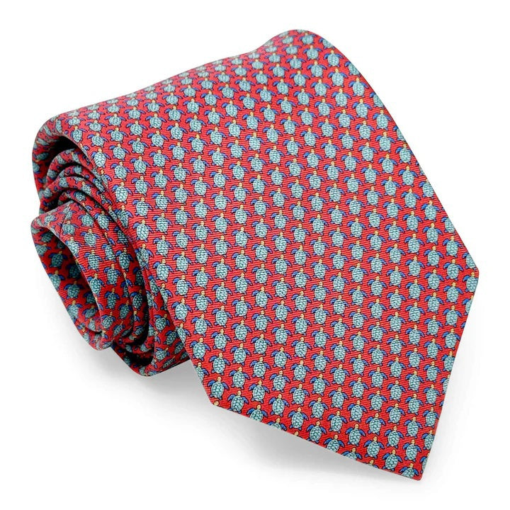 The BIRD DOG BAY PETER-BLAIR Tortuga Silk Tie in Pink features a pink background with a repeating pattern of small blue and red turtles.