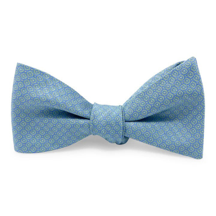 The BIRD DOG BAY PETER-BLAIR - FLOYD SILK BOW TIE IN GREEN features a small circular geometric pattern and adjustable neck, adding refined charm to any outfit. Laid flat on a white background.