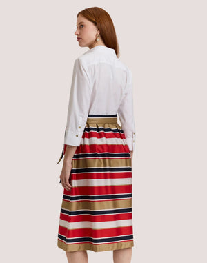 A woman stands against a plain background wearing the HINSON WU ROBIN 3/4 Sleeve Dress in Nautical Stripe, featuring red, navy, white, and tan stripes. Made from a luxurious, machine-washable cotton blend satin.