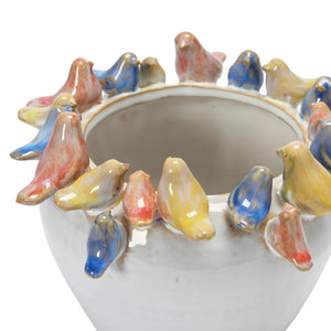 The PLANTER W BIRDS ON RIM by CREATIVE COOP is a ceramic piece made entirely from stoneware, showcasing a smooth, white exterior with small pastel-colored bird sculptures—yellow, pink, and blue—gracefully adorning the rim.