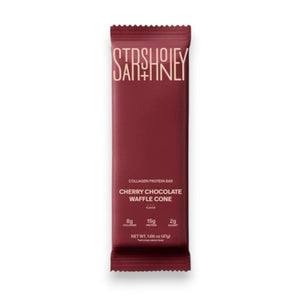 A maroon protein bar wrapper labeled “STARS+HONEY” displays the flavor “CHERRY CHOCOLATE WAFFLE CONE” with nutrition highlights: 8g collagen, 15g protein, and 2g sugar, all set against a beige background. This indulgent treat puts the rich chocolate and tart cherry combination front and center.