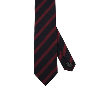 The AMANDA CHRISTENSEN Striped Jacquard Woven Silk Tie in wine red, a men’s formal accessory by AMANDA CHRISTENSEN, features diagonal black and dark red stripes and is displayed rolled up on a white background.