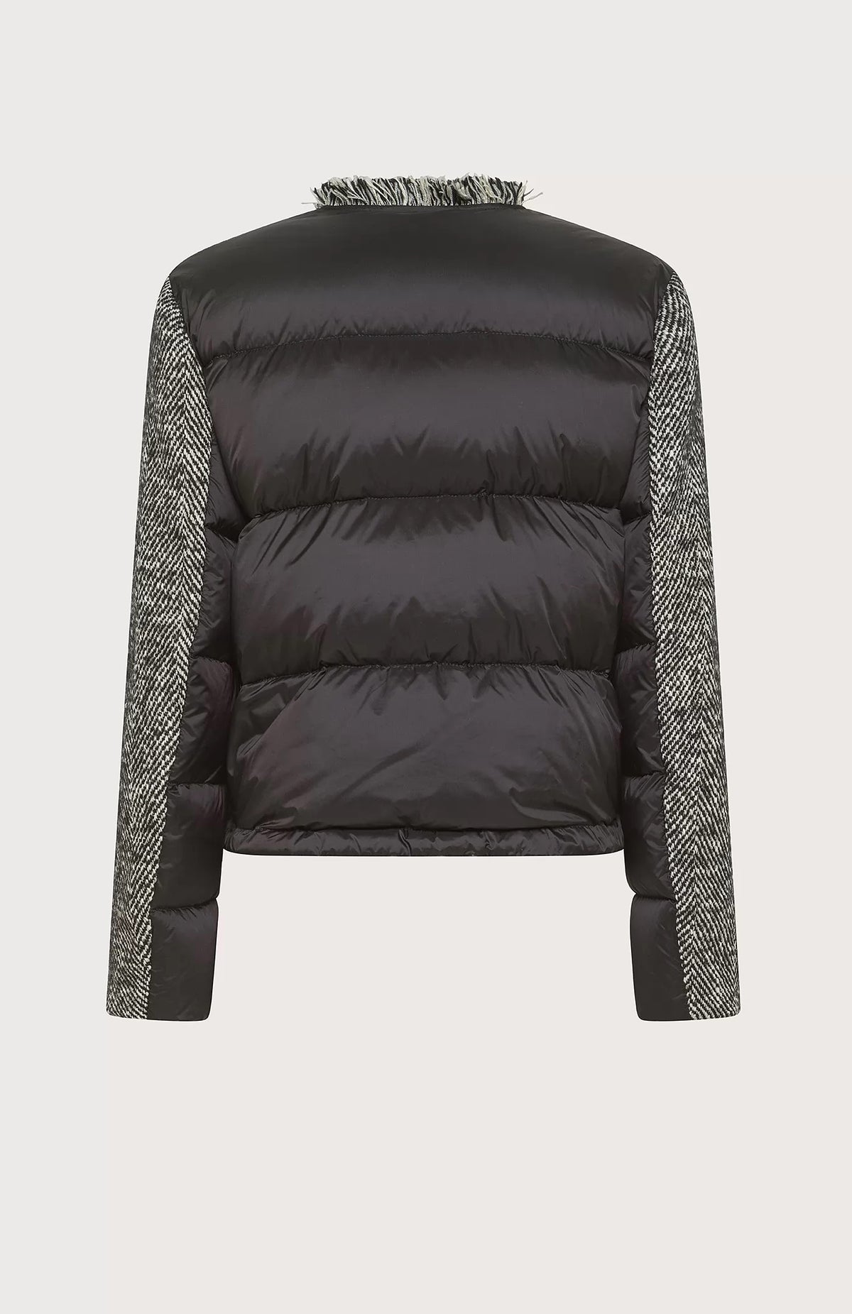 A woman stands confidently against a gradient background, wearing the SEVENTY - Wool Blend Jacket with Puffer Back by SEVENTY. She pairs the grey jacket with high collar with black tailored pants featuring a front slit and completes her outfit with black high-heeled shoes. Her long, dark hair is styled in loose waves as she looks directly at the camera.