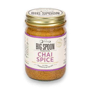 A jar of BIG SPOON ROASTERS - CHAI SPICE PEANUT ALMOND SEA SALT NUT BUTTER, featuring a gold lid and a white, purple, and gold label that highlights its handcrafted Masala Chai blend for bold chai spice flavor.