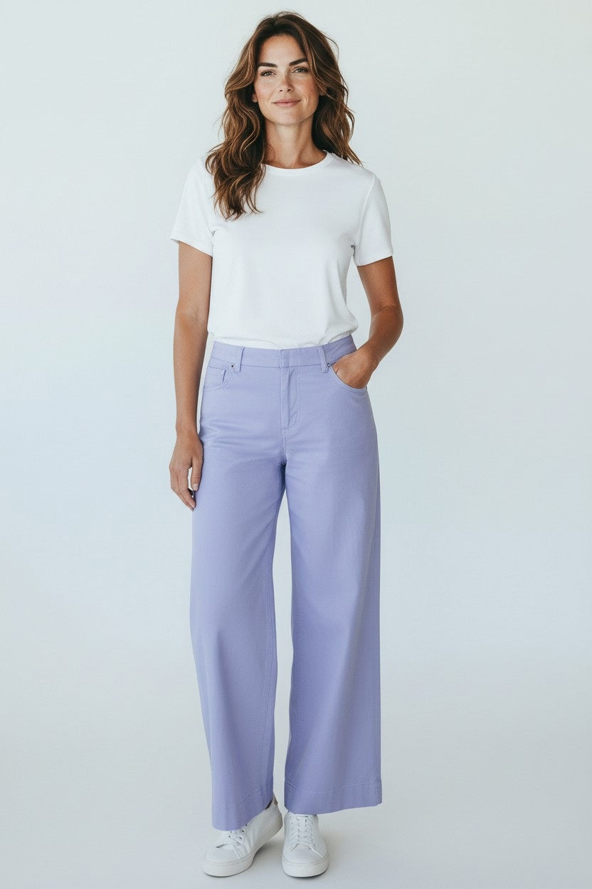 Woman standing and smiling, wearing a white t-shirt, FRANK &amp; EILEEN Wexford Wide Leg Linen Pant in Wisteria, and white sneakers against a plain light background.