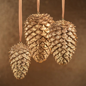 The LARGE GOLDEN PINECONE by ZODAX stands upright against a plain white background, making it a perfect addition to your holiday décor.