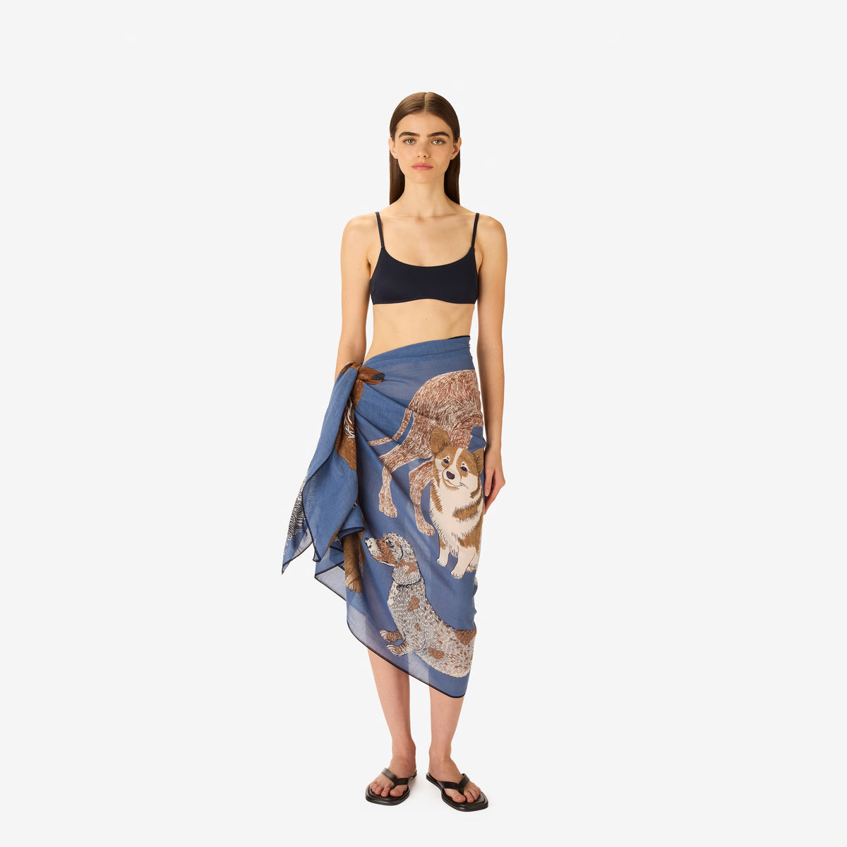 A person wears a sleeveless beige top and the INOUI EDITIONS - TOUTOU SCARF IN BLUE by INOUI, featuring a detailed animal print with white fur and brown accents, wrapped around their neck against a plain white background.