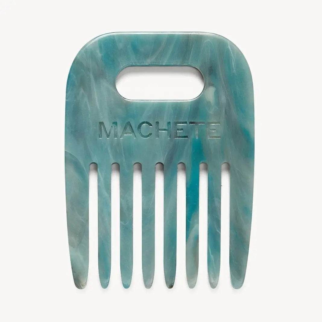 The MACHETE - NO. 4 Comb in Jadeite is a blue-green marbled wide-tooth hair pick made from Italian acetate, with a rectangular handle and "MACHETE" engraved on the front—ideal for styling curly hair.