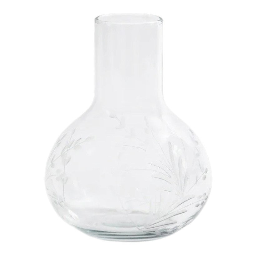 The ZODAX SHIRAZ CARAFE features a clear glass body with a wide, rounded base and narrow neck, adorned with subtle etched flower motifs—an elegant piece perfect for refined displays.