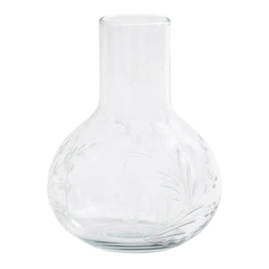 The ZODAX SHIRAZ CARAFE features a clear glass body with a wide, rounded base and narrow neck, adorned with subtle etched flower motifs—an elegant piece perfect for refined displays.