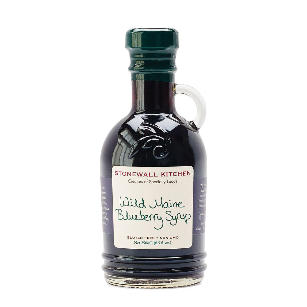 A bottle of STONEWALL KITCHEN - WILD MAINE BLUEBERRY SYRUP, featuring a dark green cap and handle. The label indicates the syrup is gluten-free and non-GMO, with a net volume of 8.5 fl oz (250 ml). Perfect for adding to your favorite smoothie recipe!